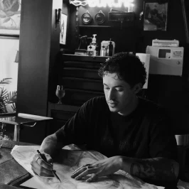 tatoueur assis dessinant un motif